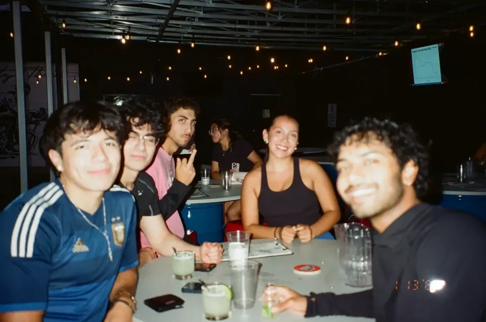 Friends at a patio table under string lights