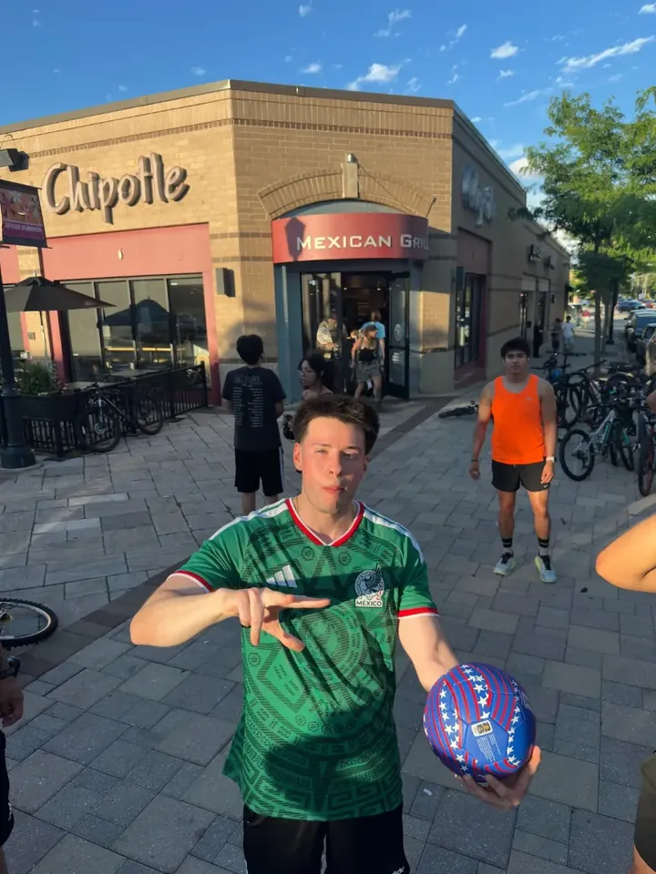A runner in a Mexico jersey holding a ball outside Chipotle
