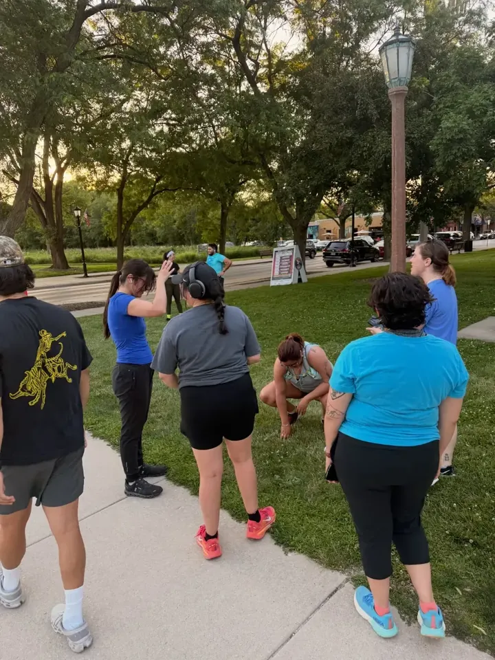 Runners standing in a loose circle on the grass
